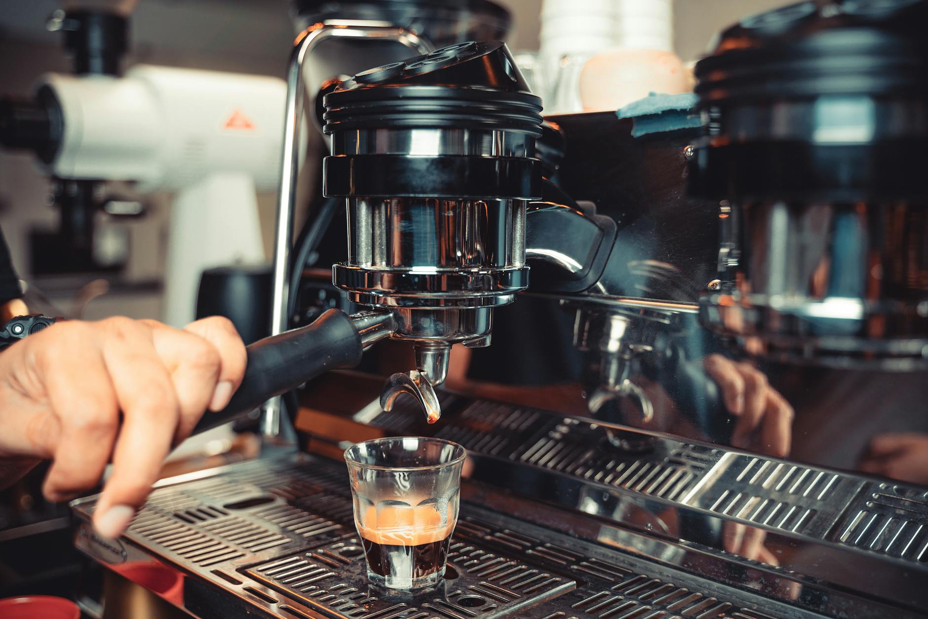 Barista przygotowuje espresso w domowym ekspresie ciśnieniowym