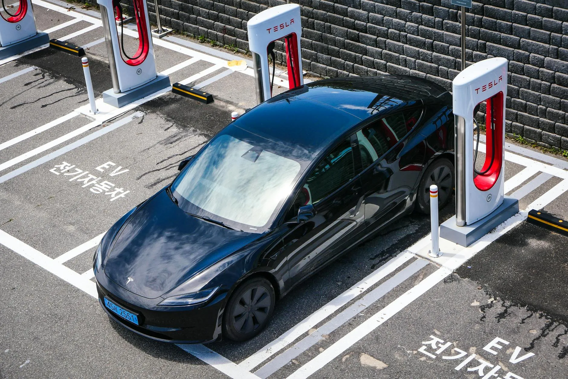Czarna Tesla ładuje się na stacji w centrum miasta