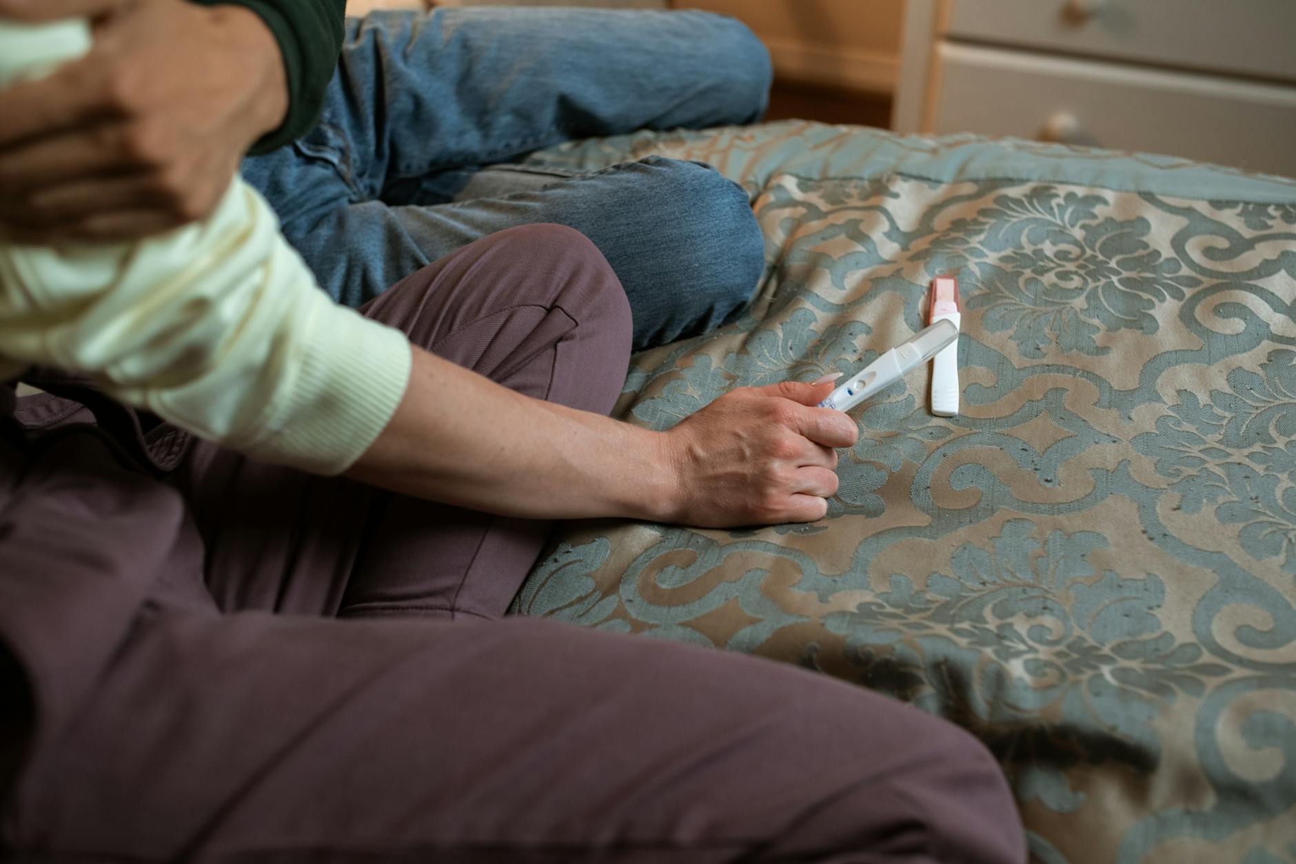 Para na łóżku cieszy się z pozytywnego testu ciążowego