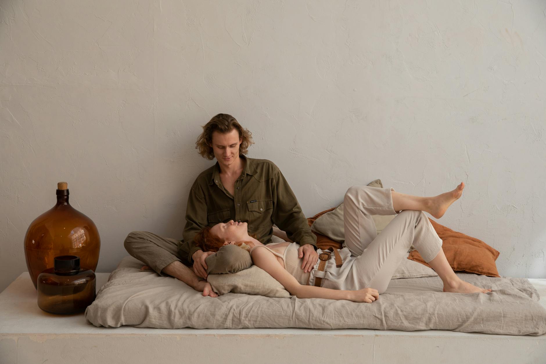 Para odpoczywająca na miękkim materacu w jasnej, minimalistycznej sypialni