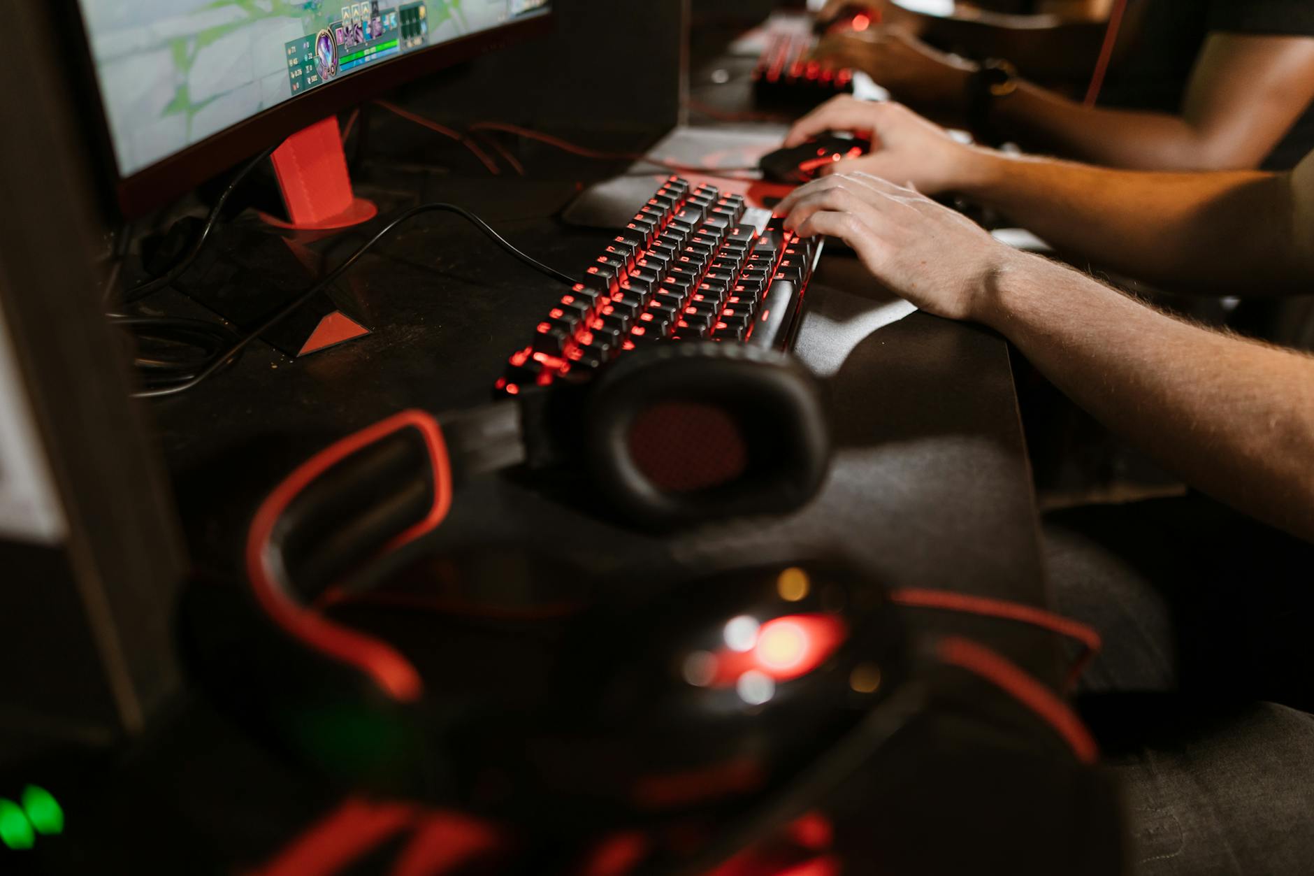 Dłonie graczy na klawiaturach mechanicznych podczas meczu e-sportowym