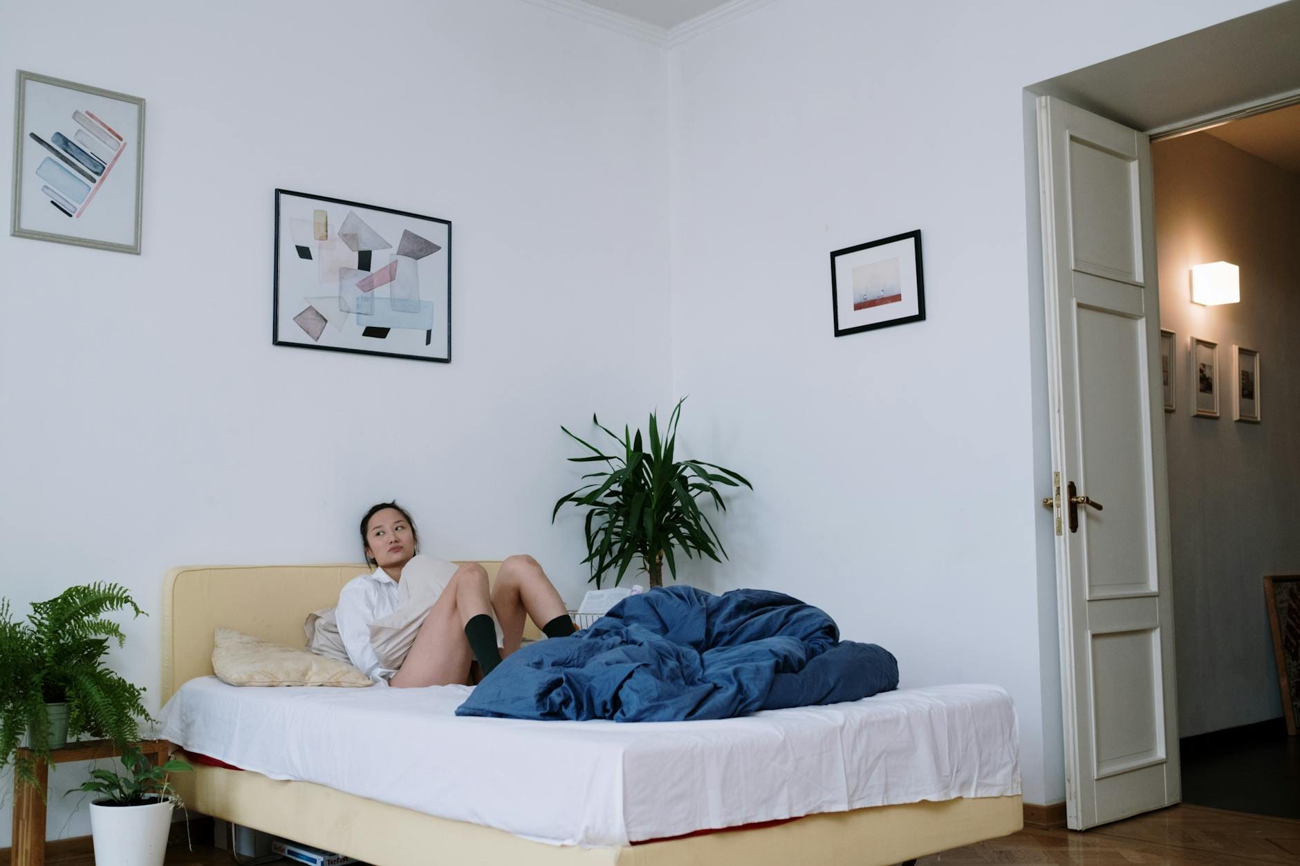 Młoda Azjatka relaksuje się na łóżku w nowoczesnej, przytulnej sypialni