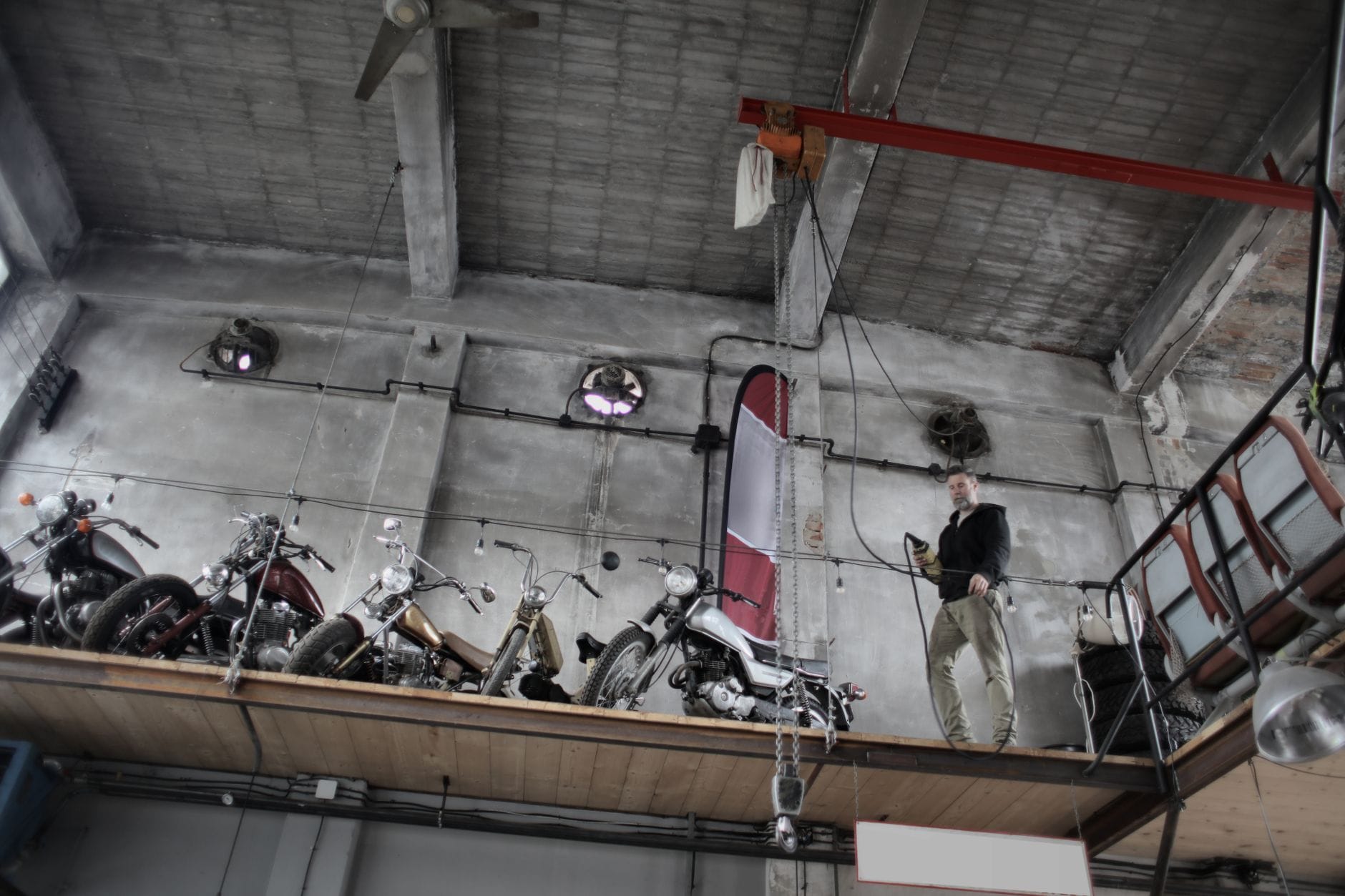 Mechanik z brodą obsługuje panel sterujący przy motocyklu w garażu
